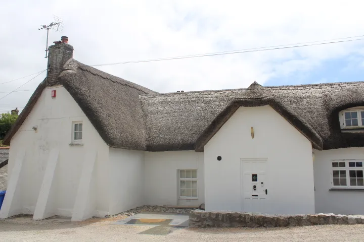 A whitewashed thatched cottage at Gwithian Farm Campsite.